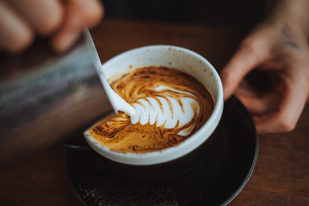 Pouring latte art into coffee