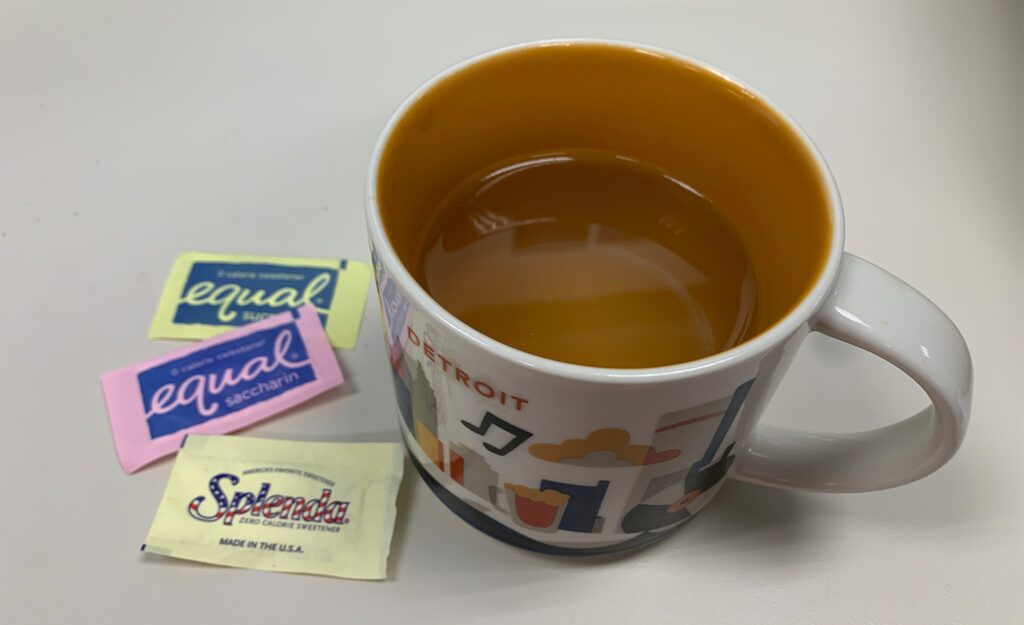 Equal And Splenda Packets Next To Coffee Mug
