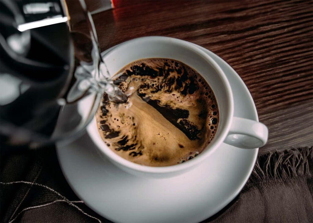 Can You Put Instant Coffee in a Coffee Maker? adding hot water to instant coffee in a mug