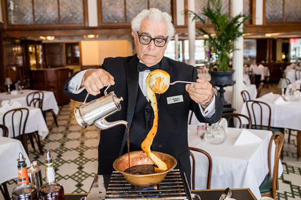 A waiter preparing a cafe brulot