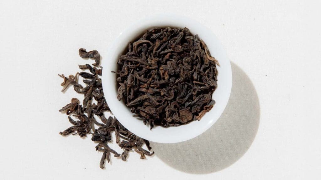 loose leaf pu-erh tea from the Art of Tea in a white porcelain dish
