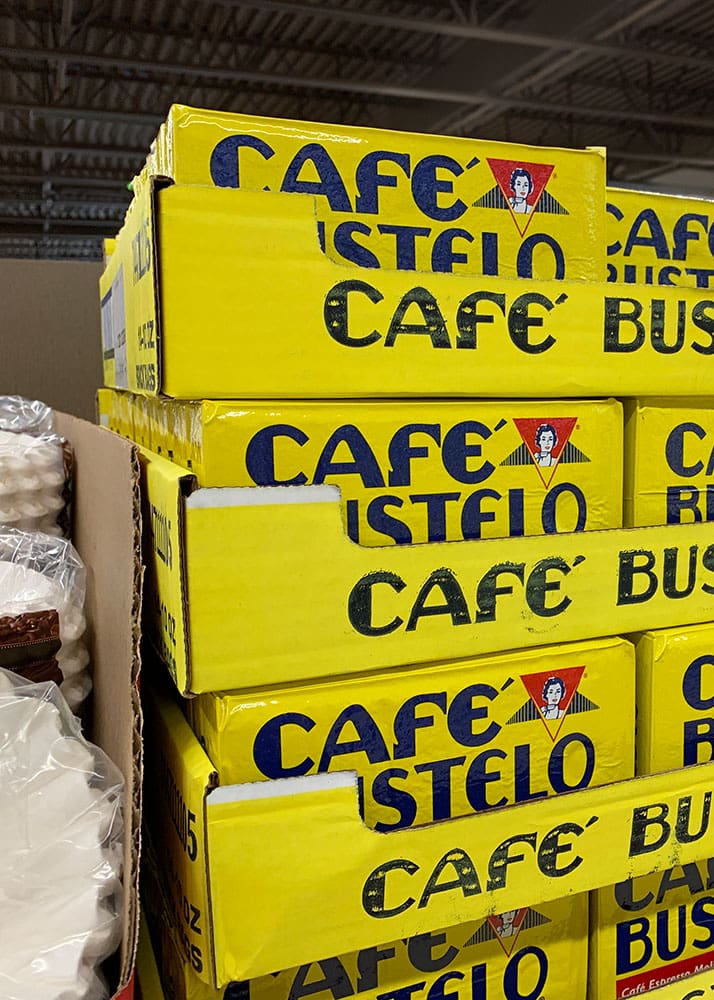 Boxes of Café Bustelo coffee stacked on a shelf at Aldi.