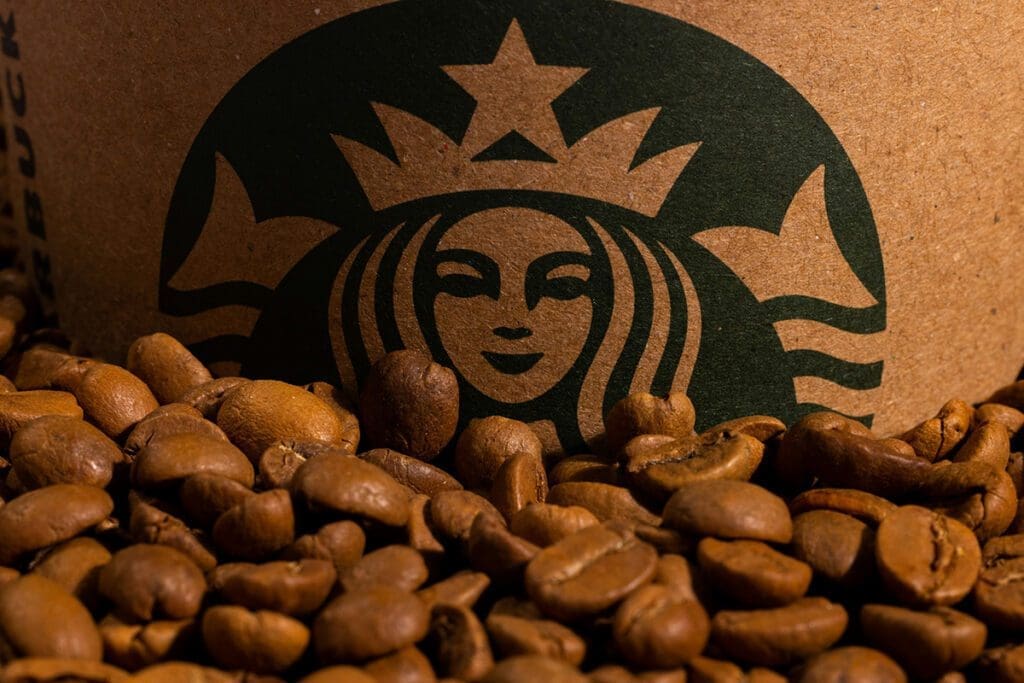 medium roast starbucks beans in the foreground with the startbucks logo in the background