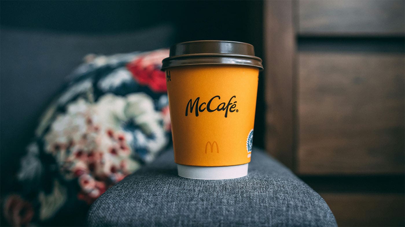 a mcdonalds coffee cup sitting on a stool in a living room