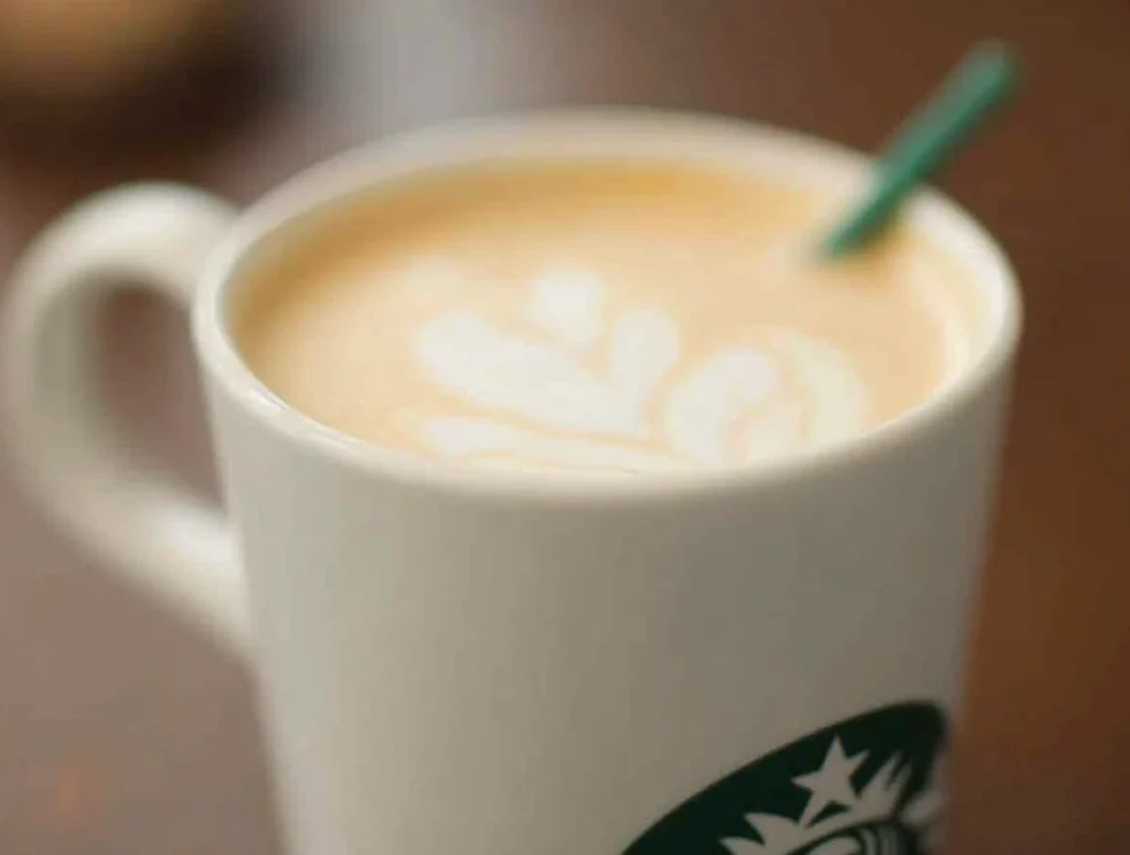 How Much Milk Is In A Venti Latte – Close-Up Of A Starbucks Latte Showing Steamed Milk Foam Art In A White Mug

