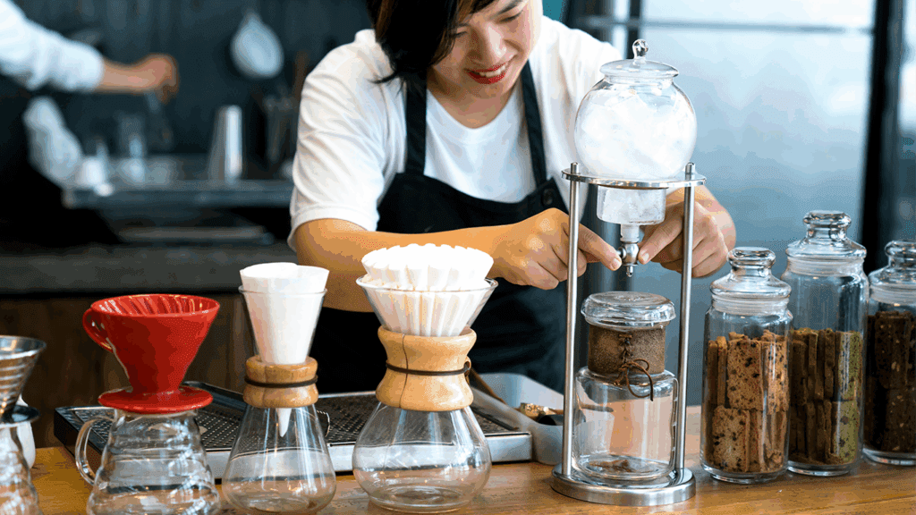 Barista preparing coffee with equipment.