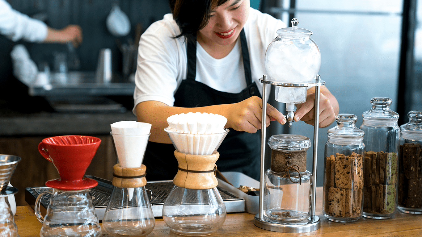 Barista preparing coffee with equipment.