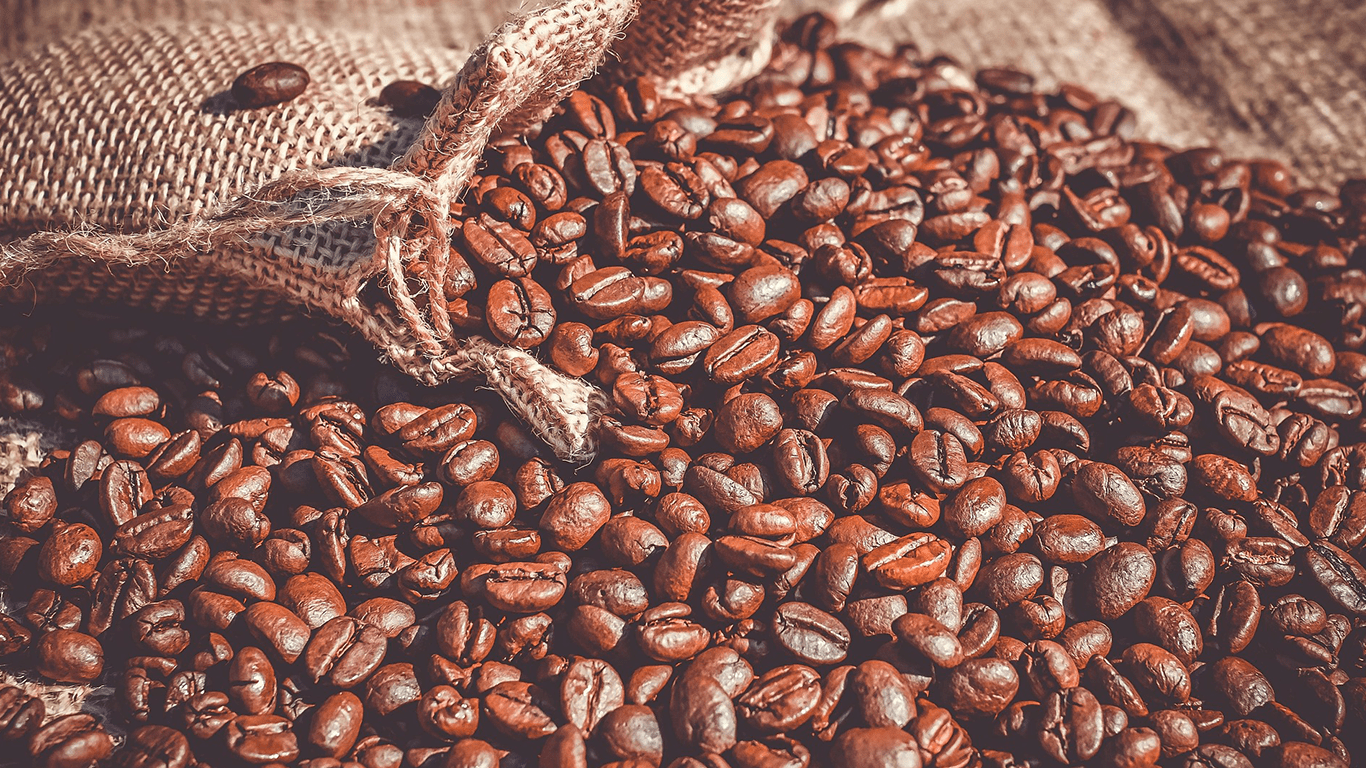 Coffee beans spilling from burlap sack