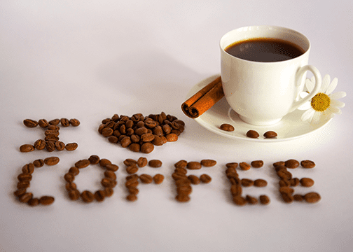 Coffee Cup And Decorative Beans Spelling “I ♥ Coffee” On Clean White Background.