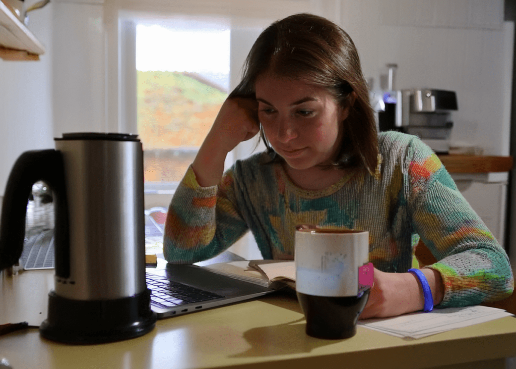 Person studying with a mug of coffee and an espresso.