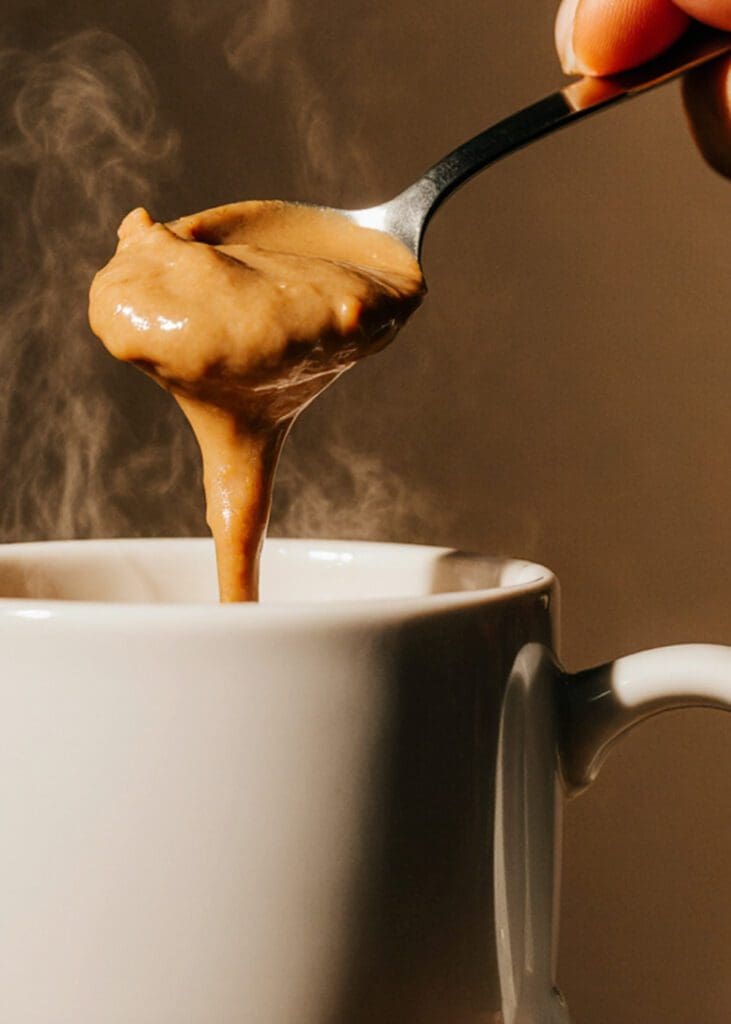 Spoonful of peanut butter over coffee