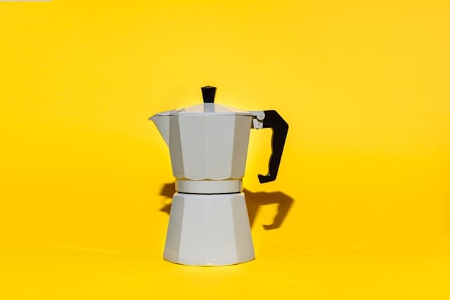 White coffee maker on yellow background