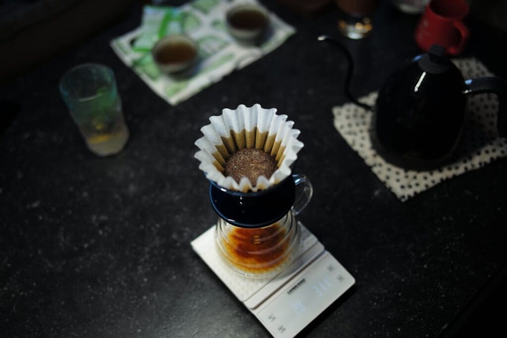 a cup of coffee with whipped cream and a spoon on a table