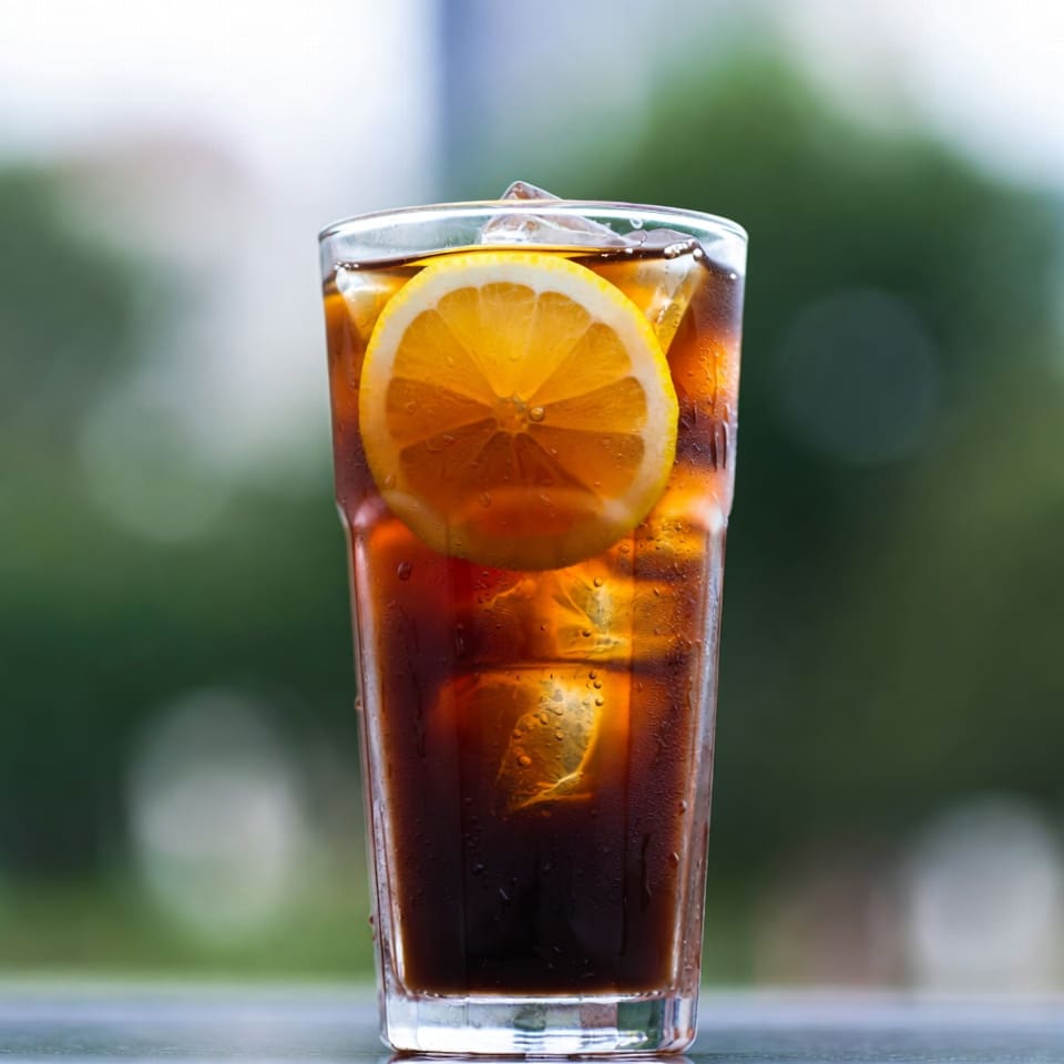 Close-up of a Mazagran iced lemon espresso showing the layered espresso and citrus in a tall glass