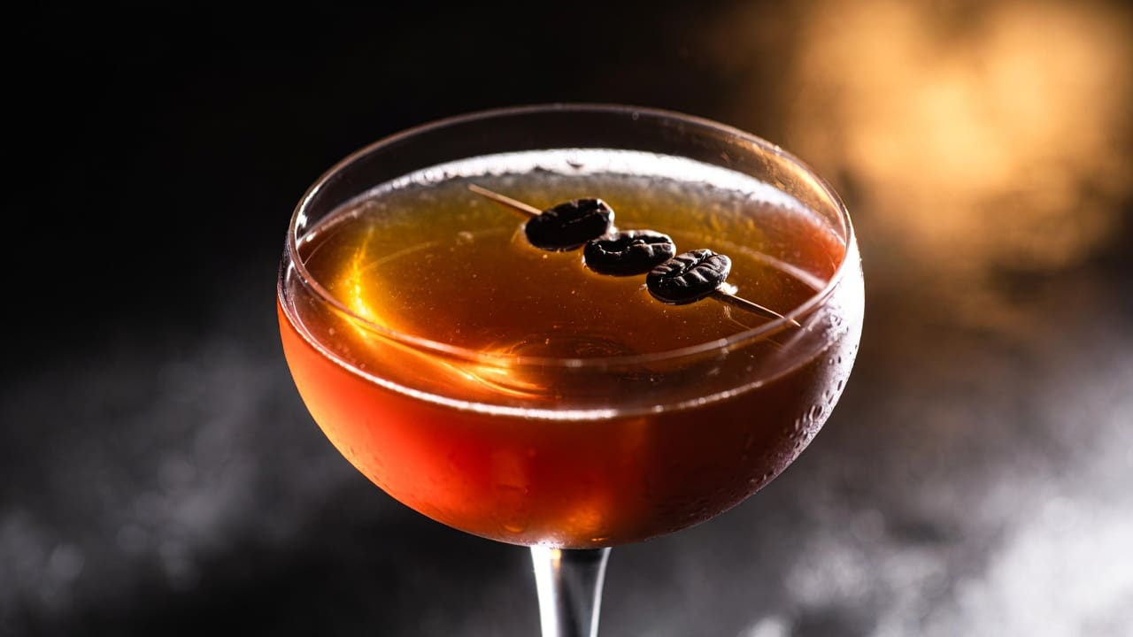 Stirring the Revolver cocktail in a mixing glass with large ice cubes