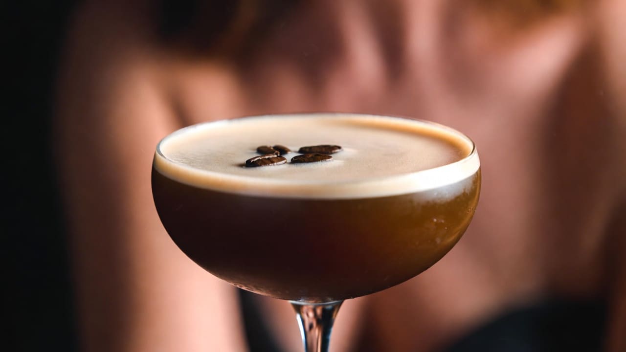 Bourbon, coffee liqueur, and orange bitters arranged for the Revolver cocktail