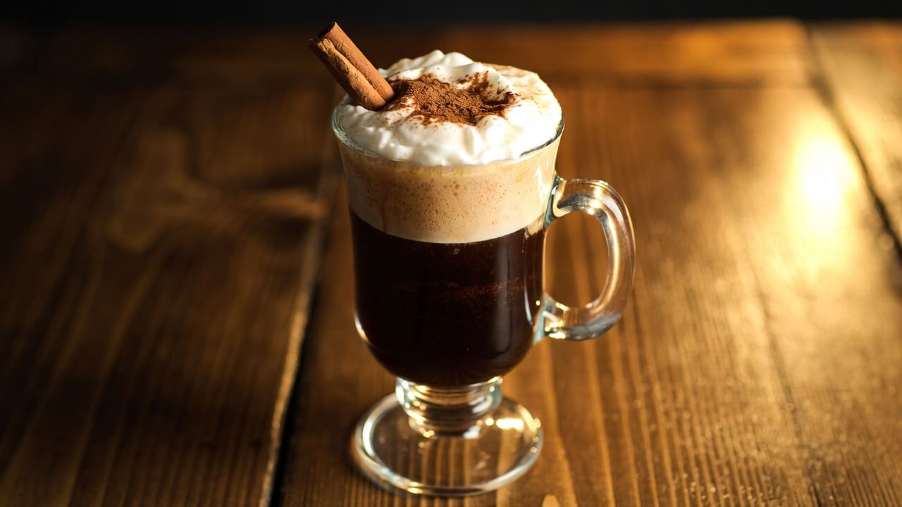 Irish coffee cream being floated over a bar spoon